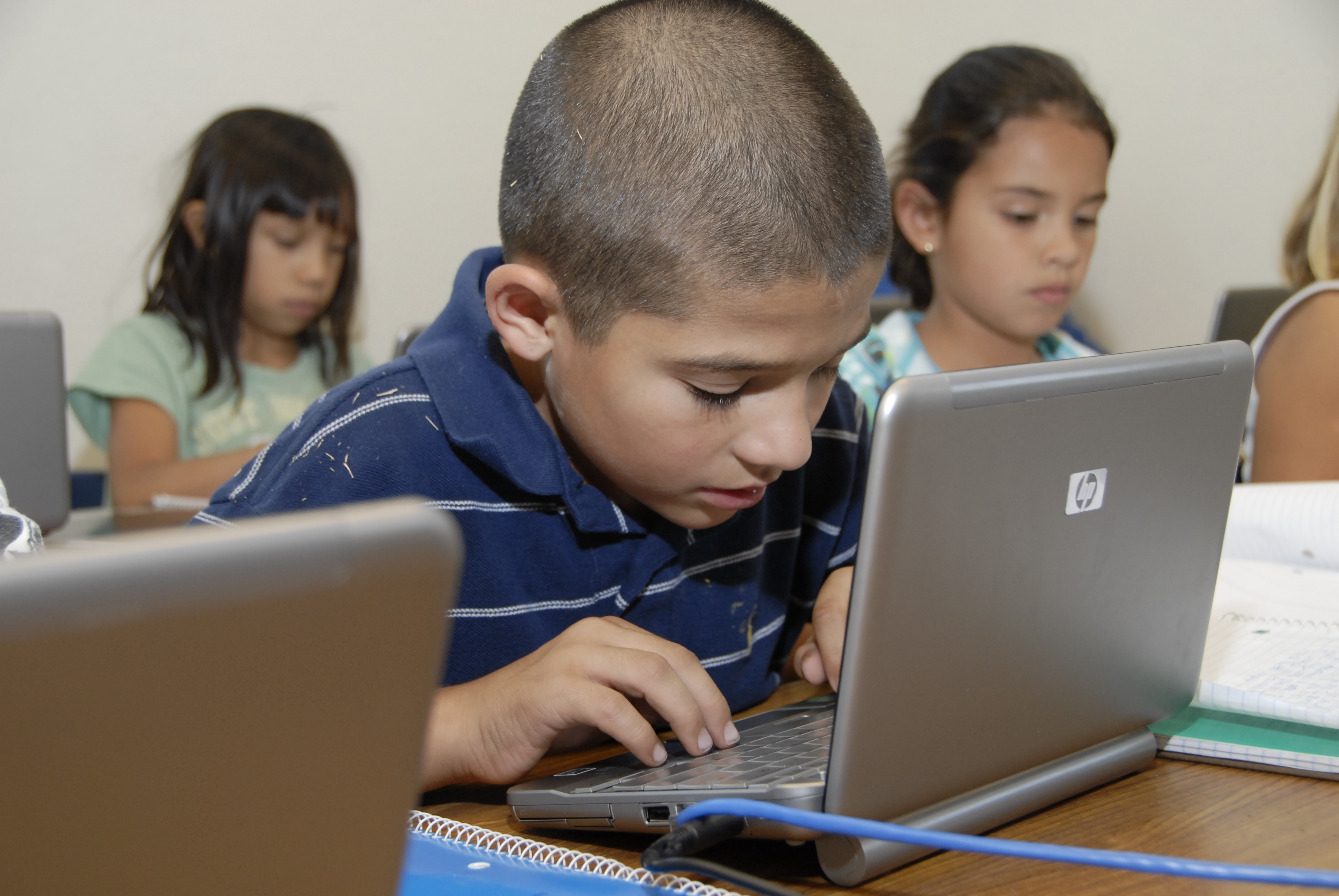 A student works diligently on his laptop